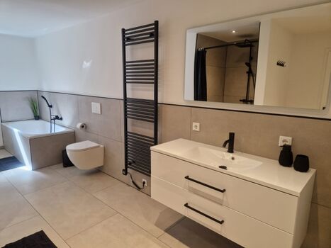 Badezimmer mit Badewanne und Dusche