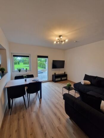 Wohnzimmer mit großem TV und Essbereich