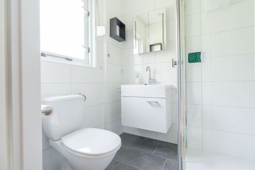 Badezimmer 1 mit Dusche, Waschbecken und Toilette