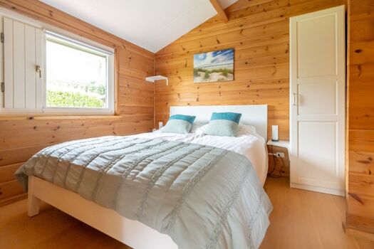 Schlafzimmer 1 mit Doppelbett, Schrank und TV