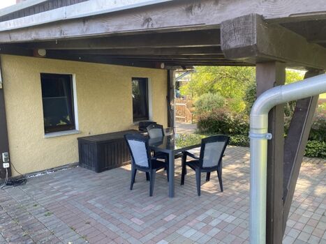 überdachte Terrasse mit Gartenmöbel