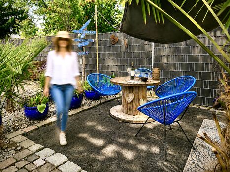 Sitzplatz mit Acapulco-Sessel und Sonnensegel.