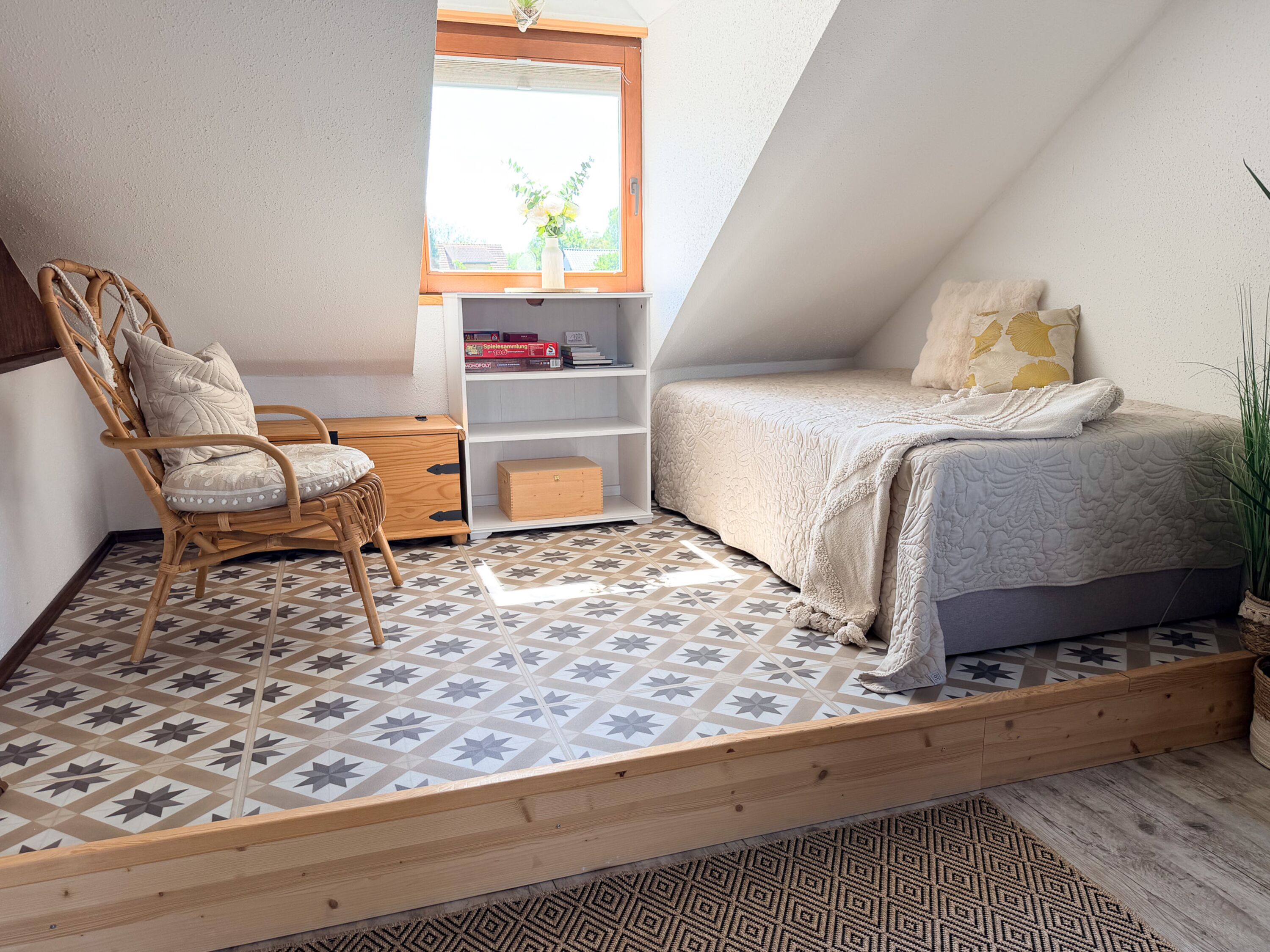Boxspringbett 1,00 x 2,00m im Obergeschoss. Das Bett steht auf einem Podest unter einer Dachschräge.