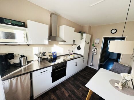 Küche mit Herd, Kühlschrank und Staubsauger