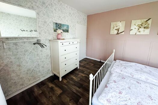 Schlafzimmer mit Kommode und Kleiderstange