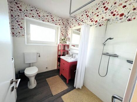 Badezimmer mit ebenerdiger Dusche und WC