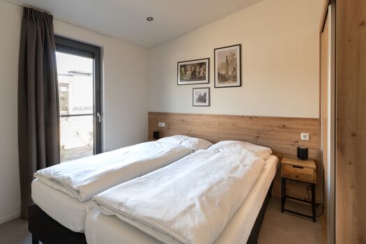 zwei Schlafzimmer in heller Holzoptik