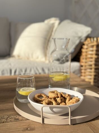 dickes Rattan, cremefarbene Kissen, volle Sonne am Nachmittag