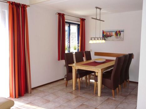 Esszimmer mit großem Tisch und 6 bequemen Stühlen