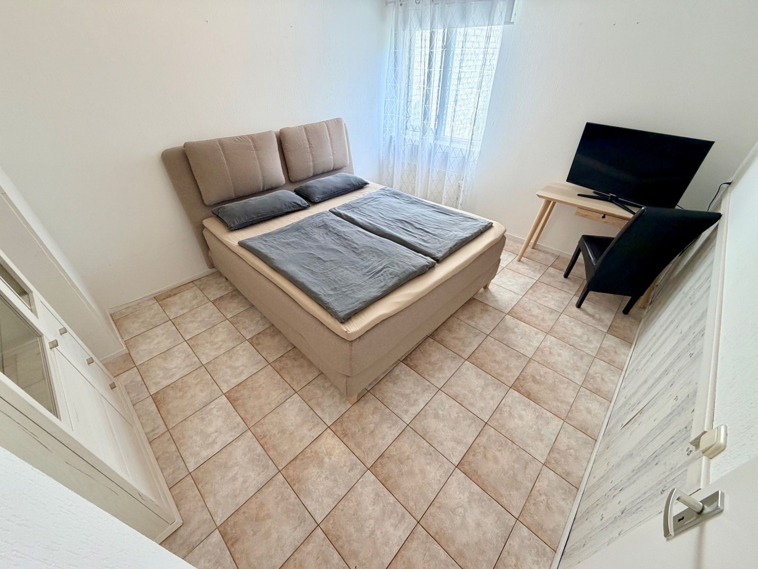 Gemütliches Schlafzimmer im EG mit Boxspringbett und TV