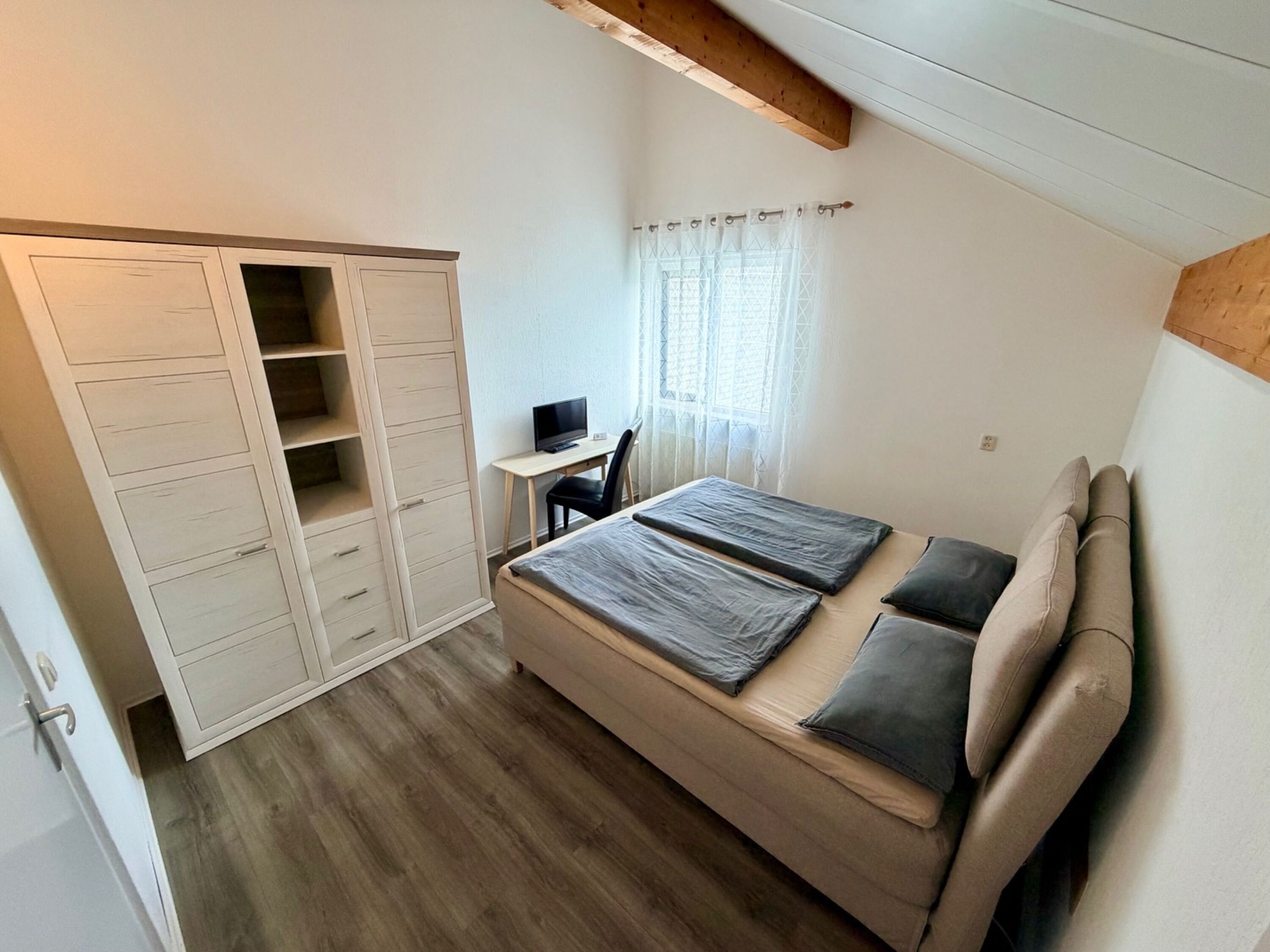 Gemütliches Schlafzimmer im OG mit Boxspringbett, großem Schrank, Schreibtisch und TV