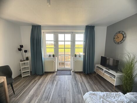 Wohn- und Schlafraum mit Blick in die friesische Landschaft