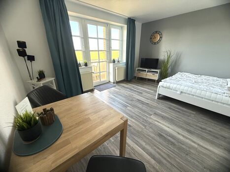 Wohn- und Schlafraum mit Blick in die friesische Landschaft