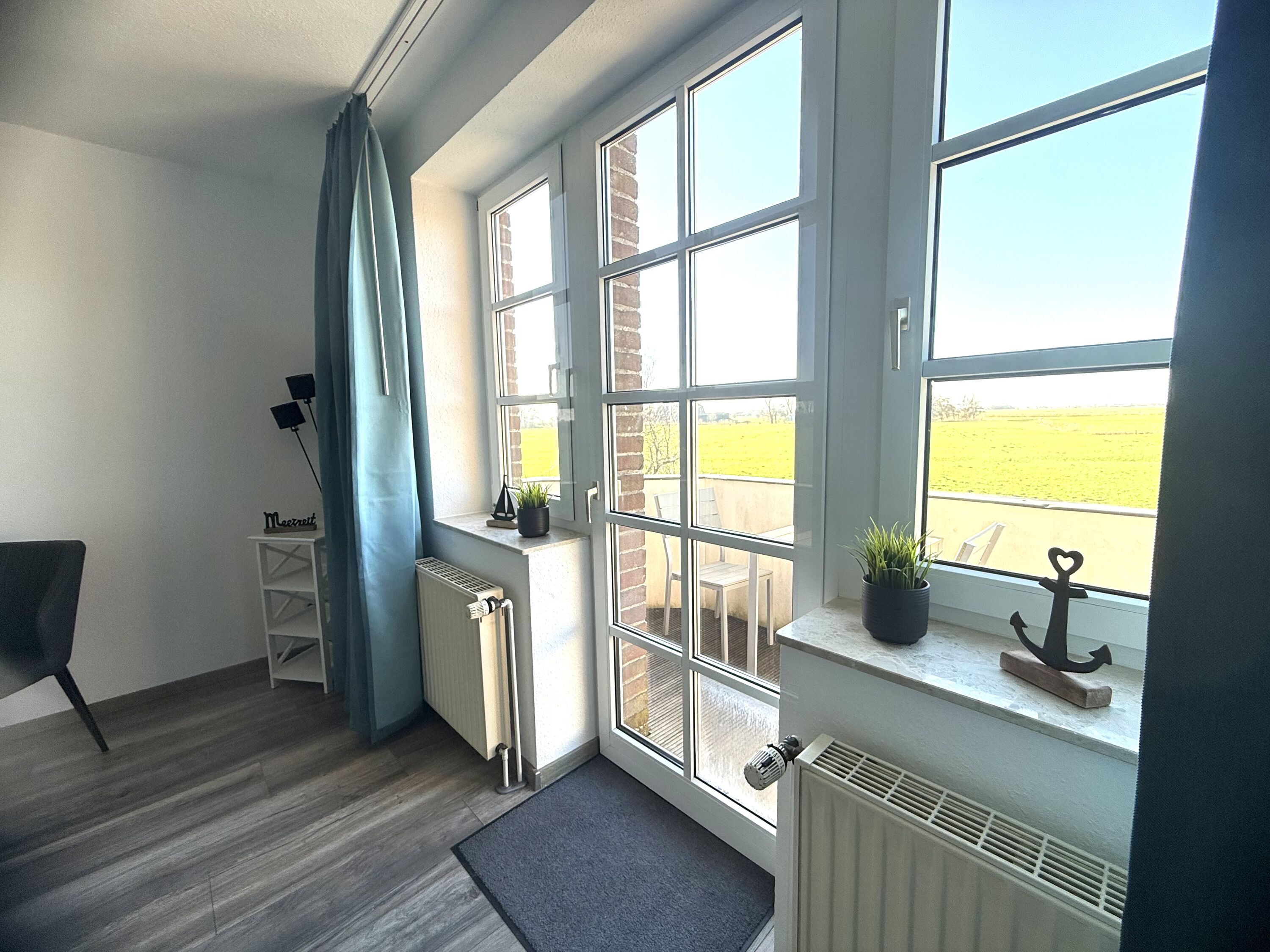 Wohn- und Schlafraum mit Blick in die friesische Landschaft