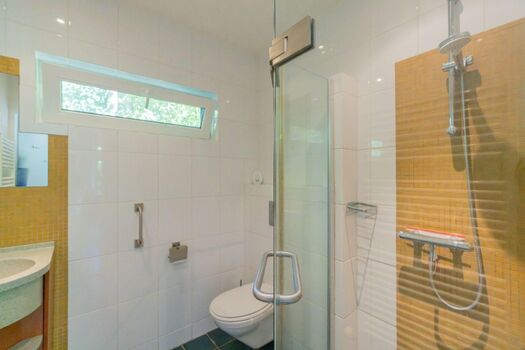 Badezimmer mit Dusche, Toilette und Waschbecken