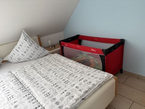 Schlafzimmer mit Kinderreisebett