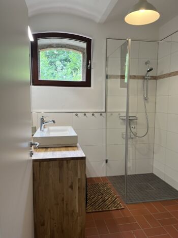 Bad mit Dusche, Waschbecken, Waschmaschine und Trockner