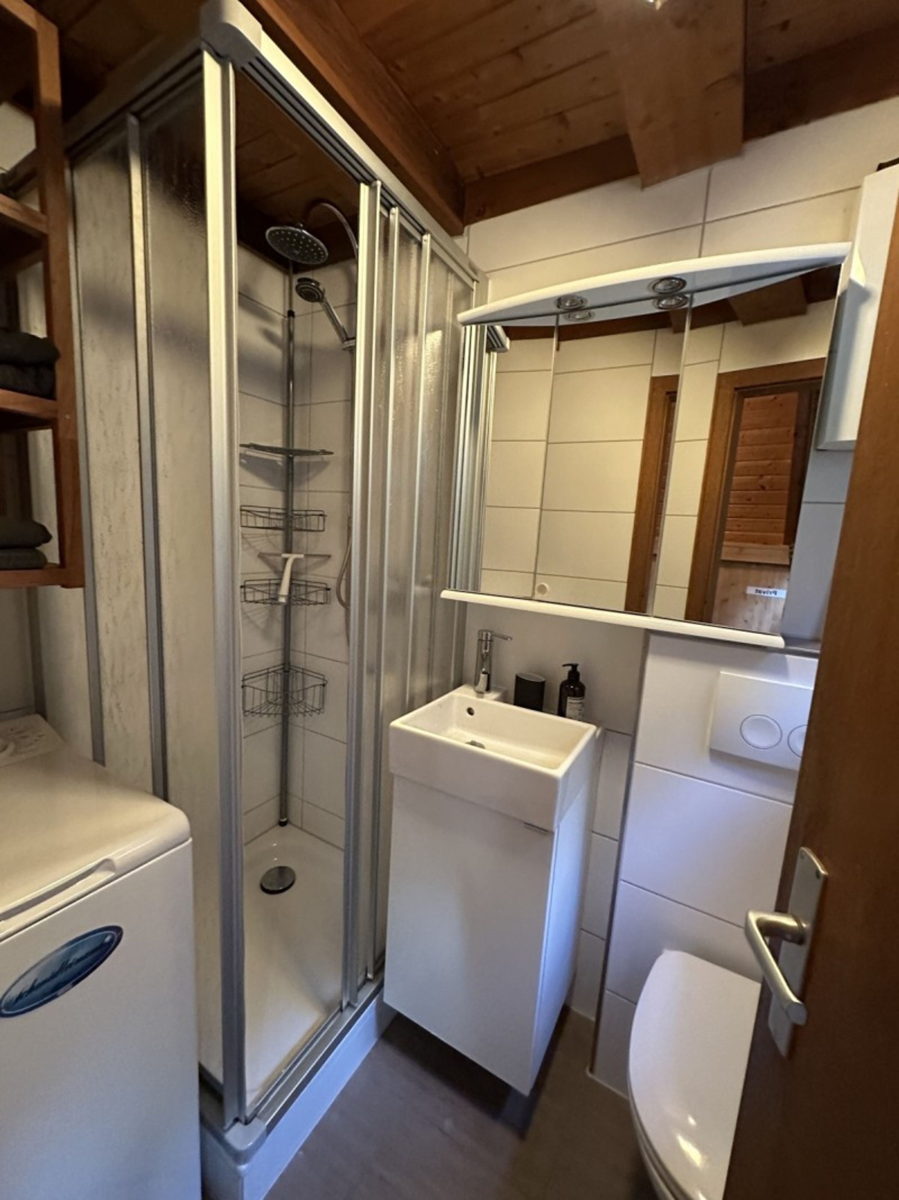 Badezimmer mit Dusche und Waschmaschine