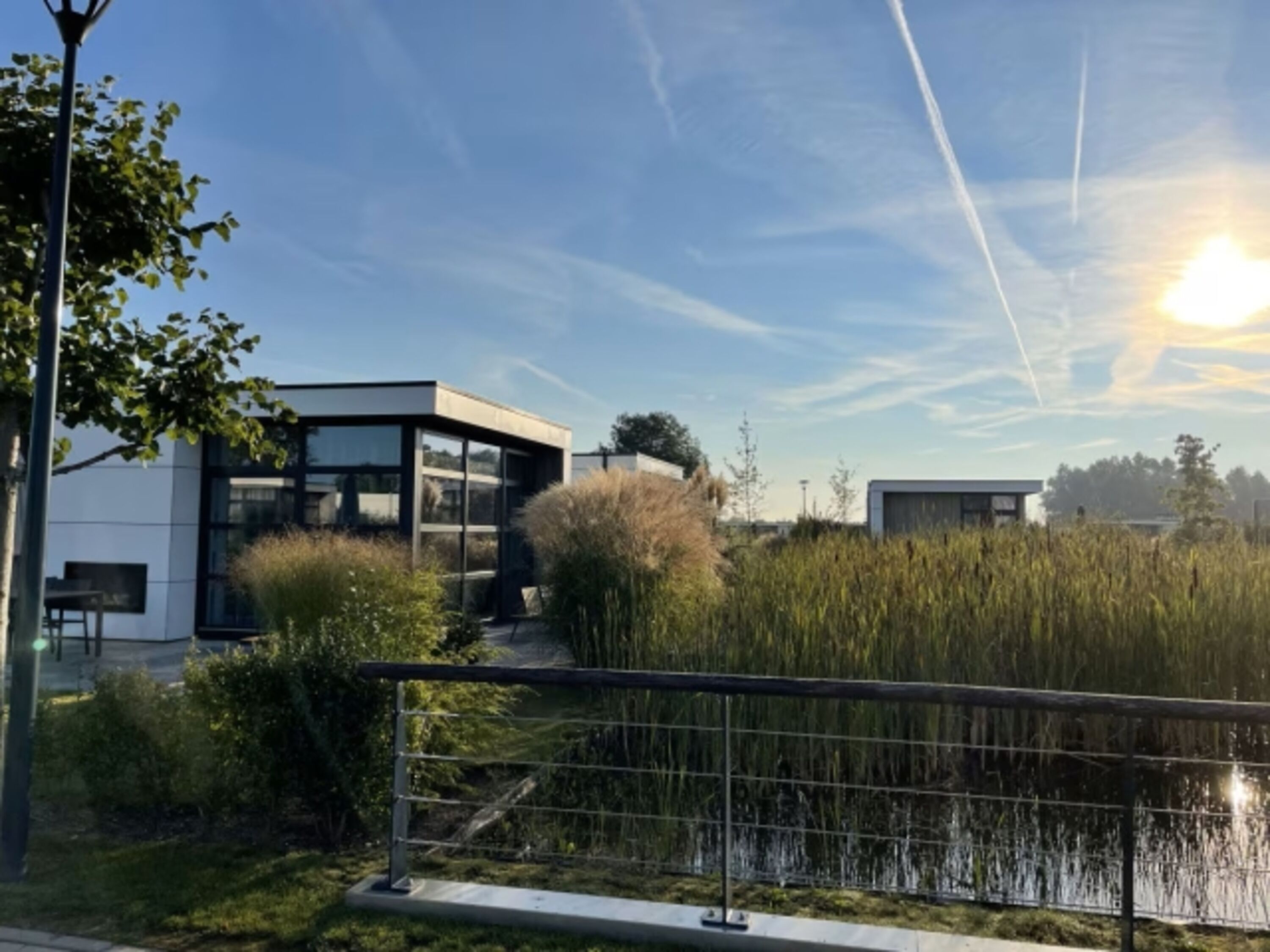 Das Chale liegt mit Blick auf das Parkgewässer aus Wohnzimmer und Garten