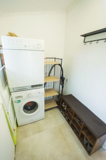 Im Eingangsbereich finden Sie eine Garderobe, eine Bank mit Schuhregal, eine Waschmaschine und einen Trockner.