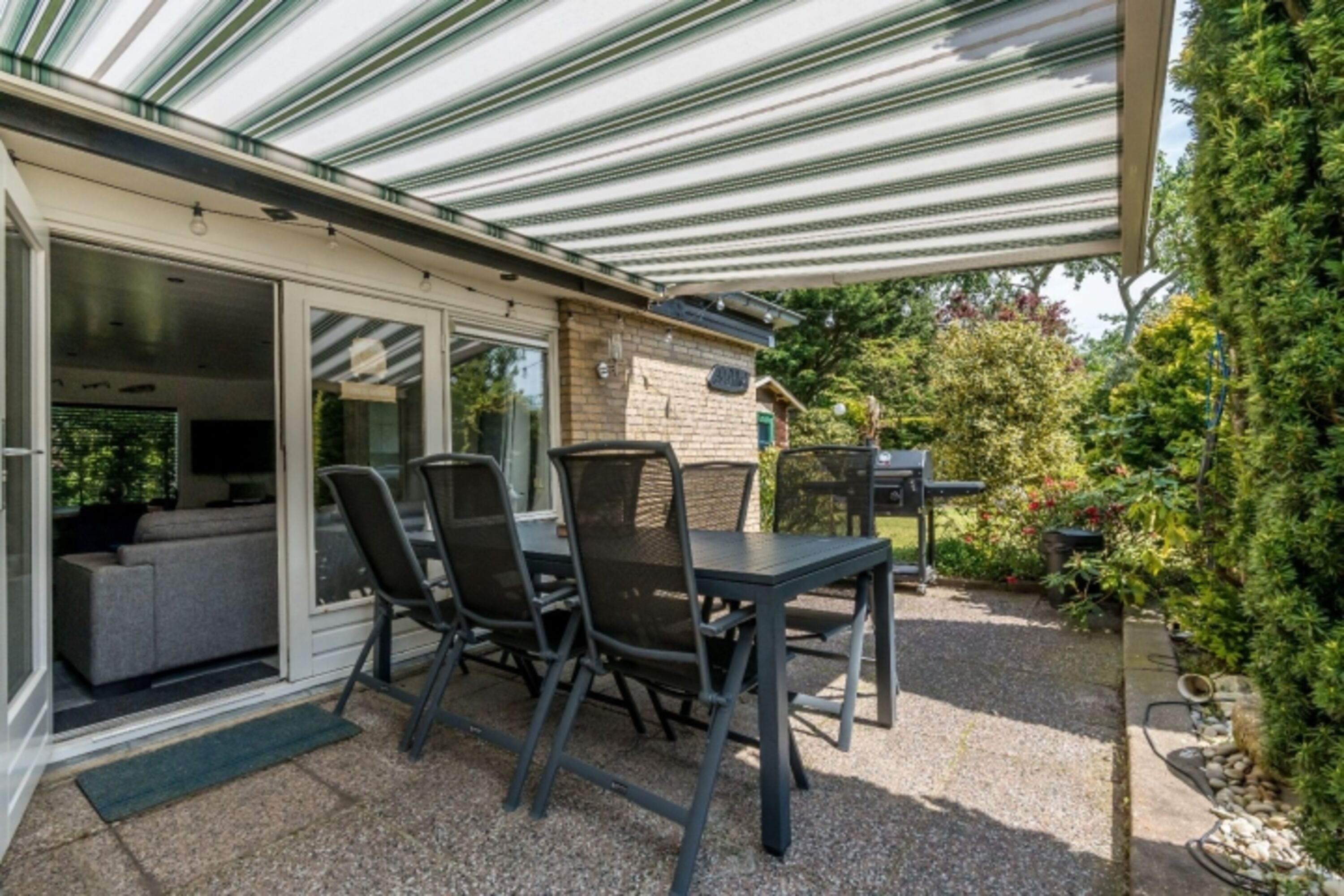 Die Terrasse mit Gartenmöbel und Markise