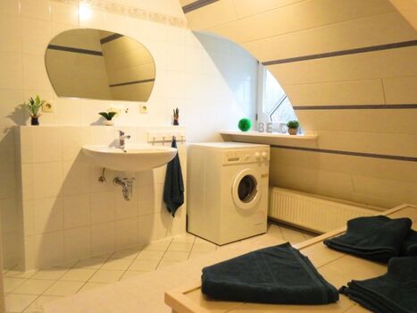 Das Badezimmer mit Dusche und Waschmaschine