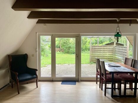 Wohnzimmer mit großer Fensterfront und Gartenblick