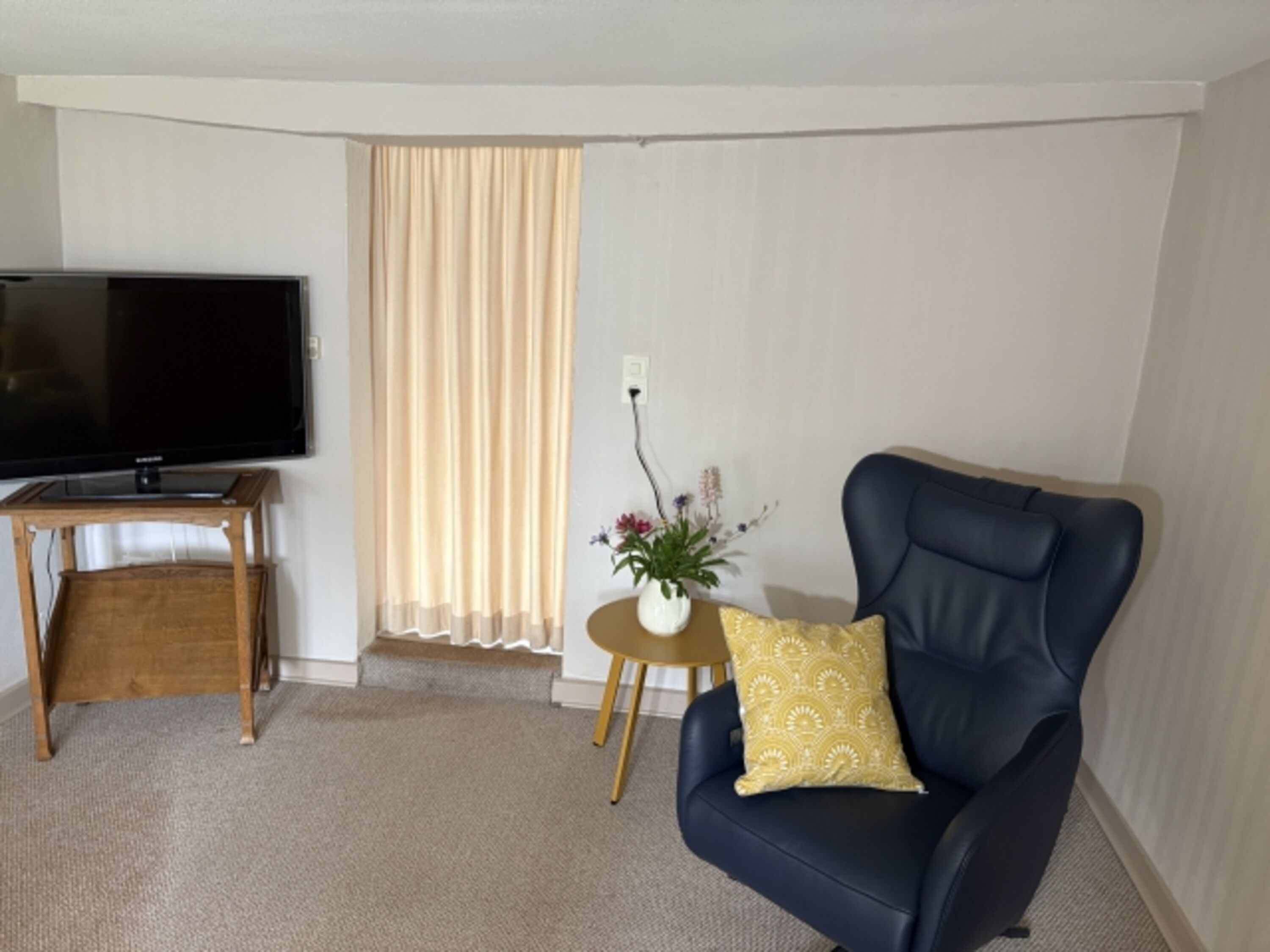 Wohnzimmer mit TV und Relaxsessel