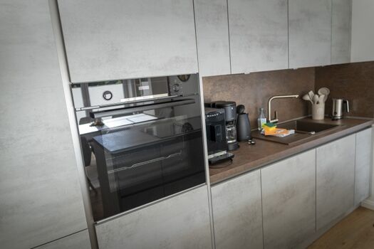 Voll ausgestattete Küche mit Spülmaschiene, Backofen und Kaffeevollautomat