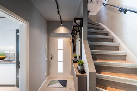 Diele mit Regenschirmen und Schuhlöffel im Erdgeschoß mit Blick auf die Hauseingangstür, Richtung Garten /Hof/Terrasse. Links Einblick in die Küche.