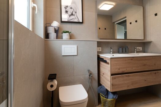 Bad OG: Bodengleiche Regendusche inklusive Pflegemittel: Shampoo   Duschgel   Seife, Hand- und Duschtücher, Doppelwaschbecken, Handtuchtrockner, Hygienedusche am WC, Toilettenpapier, Antibeschlagspiegel.