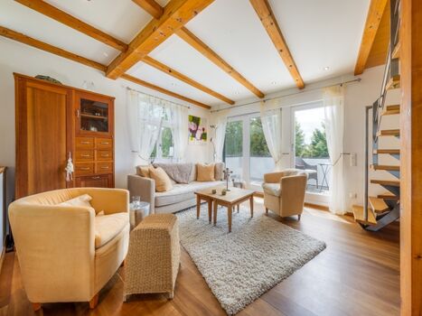 Wohnzimmer im Ferienhaus mit Balkon und Gartenblick