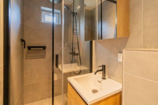 Modernes Badezimmer mit Regendusche, Waschbecken und Toilette