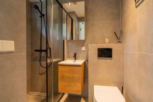 Modernes Badezimmer mit Regendusche, Waschbecken und Toilette