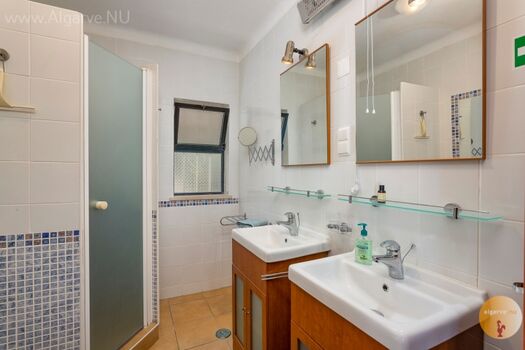 Familienbadezimmer mit begehbarer Dusche, Toilette und zwei Waschbecken