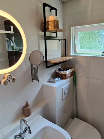 Badezimmer mit Kosmetikspiegel und ausreichend Ablagemöglichkeiten