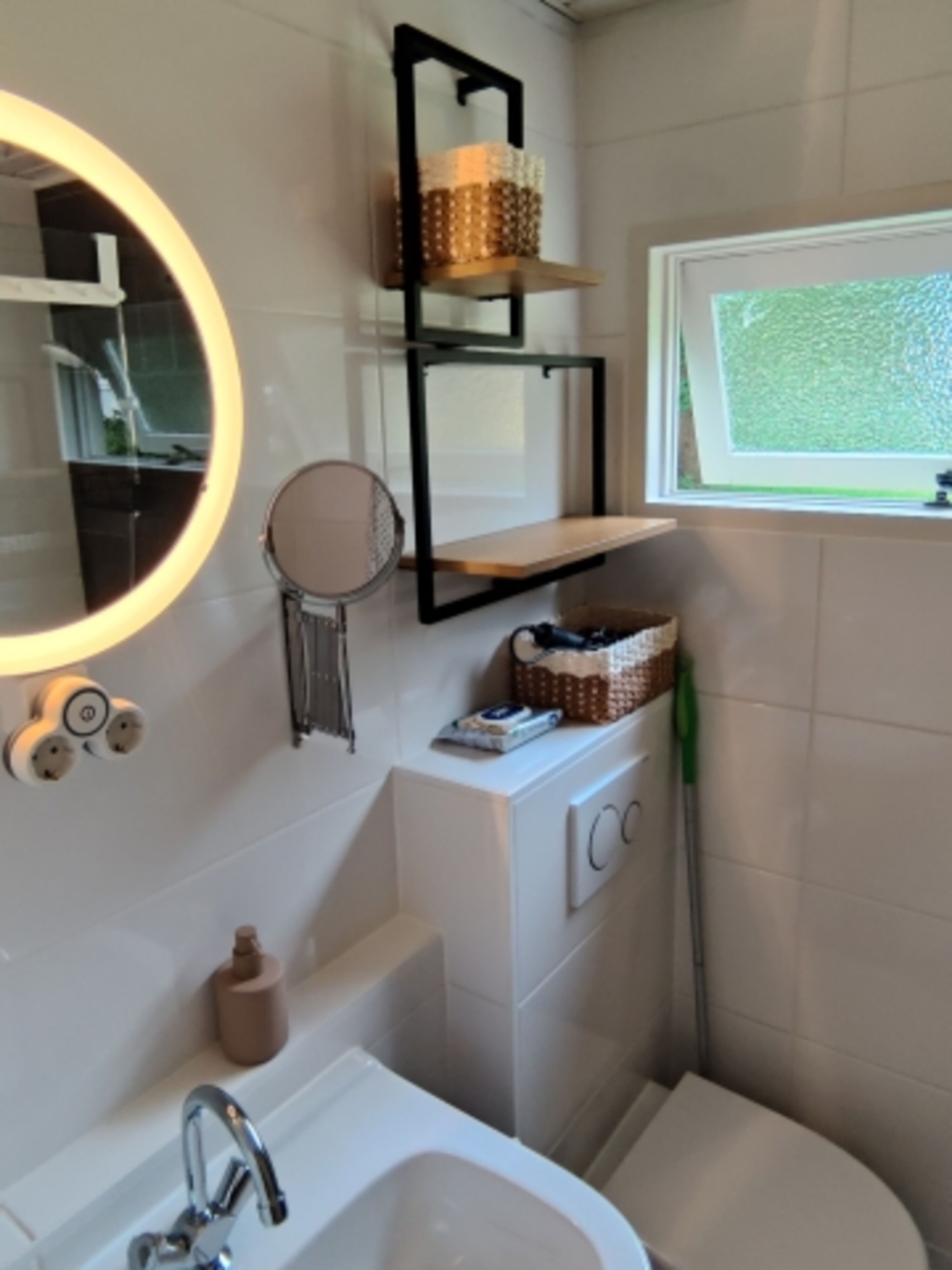 Badezimmer mit Kosmetikspiegel und ausreichend Ablagemöglichkeiten