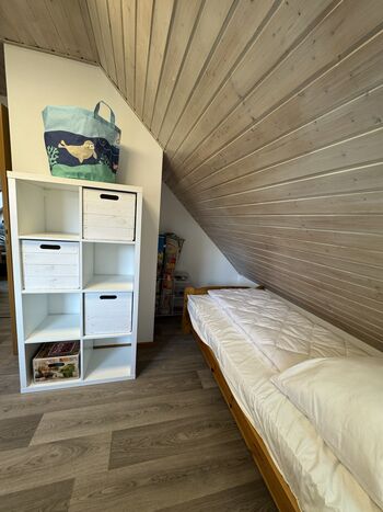 Schlafzimmer links im Obergeschoss mit 2 Einzelbetten und Spieleteppichen