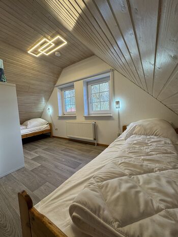 Schlafzimmer links im Obergeschoss mit 2 Einzelbetten und Spieleteppichen