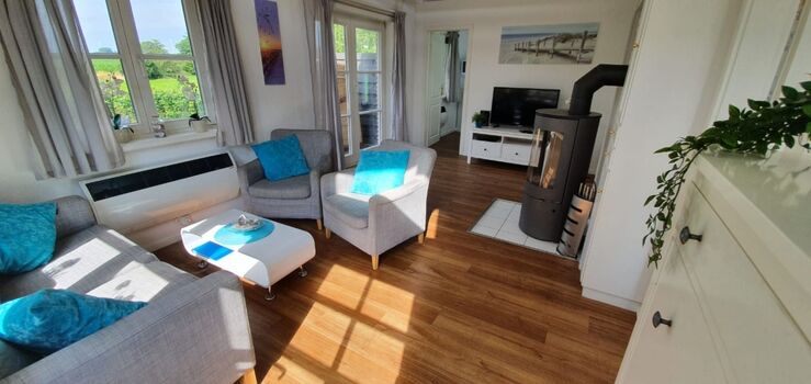 Das Wohnzimmer mit Kamin und Blick ins Grüne