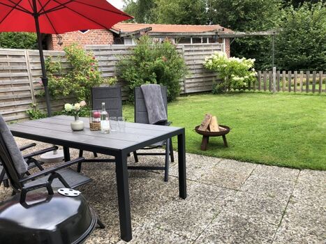 Garten mit Gartenmöbeln, Sonnenschirm, Feuerschale und Grill
