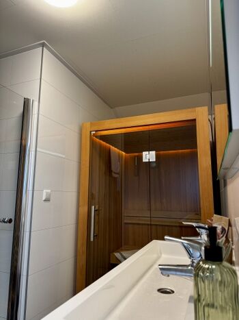 Neben der Sauna ist im Bad eine Dusche und ein Waschbecken zu finden
