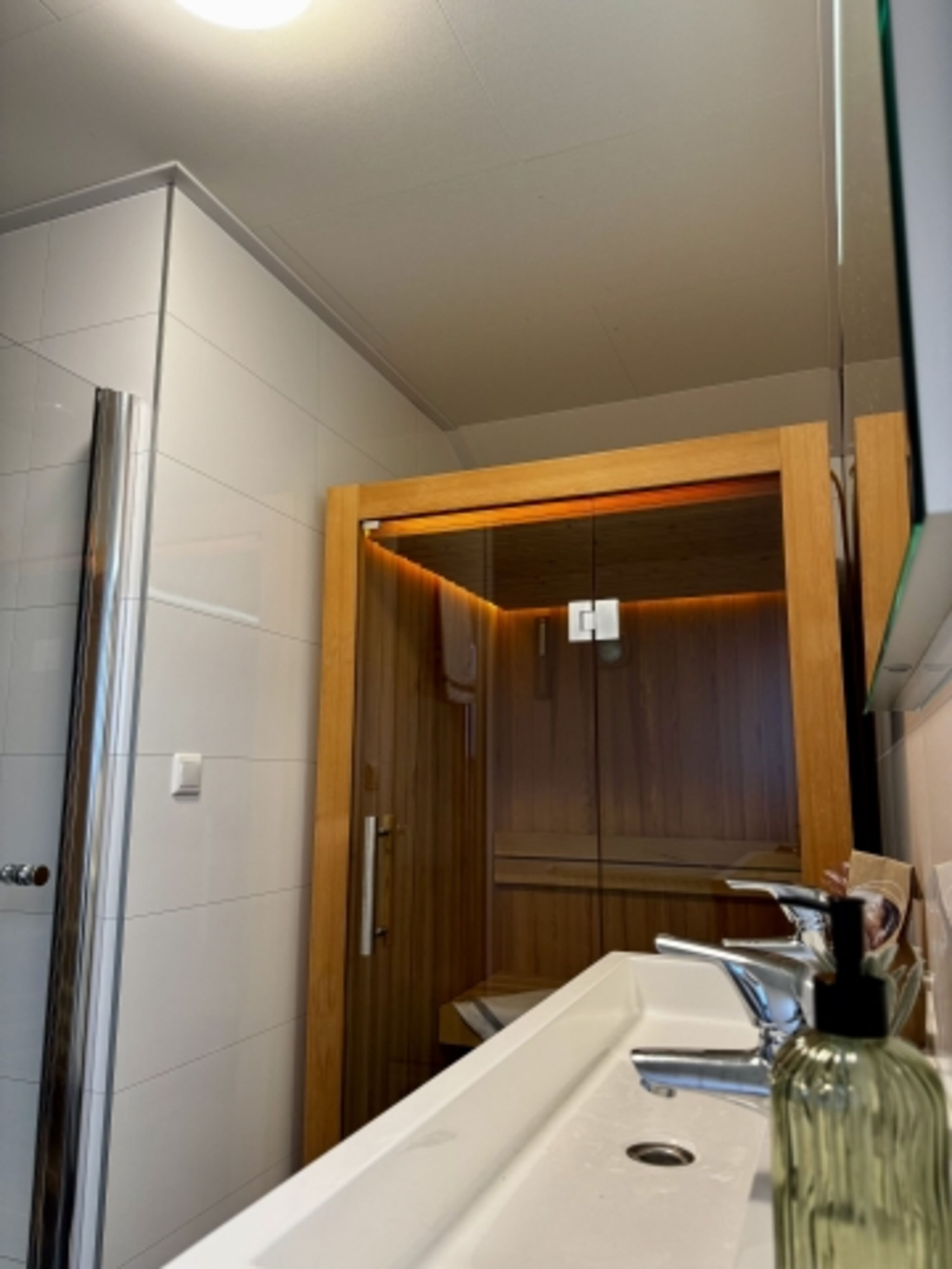 Neben der Sauna ist im Bad eine Dusche und ein Waschbecken zu finden