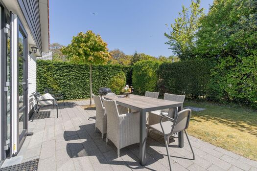 Die sonnige Terrasse mit Gartenmöbel