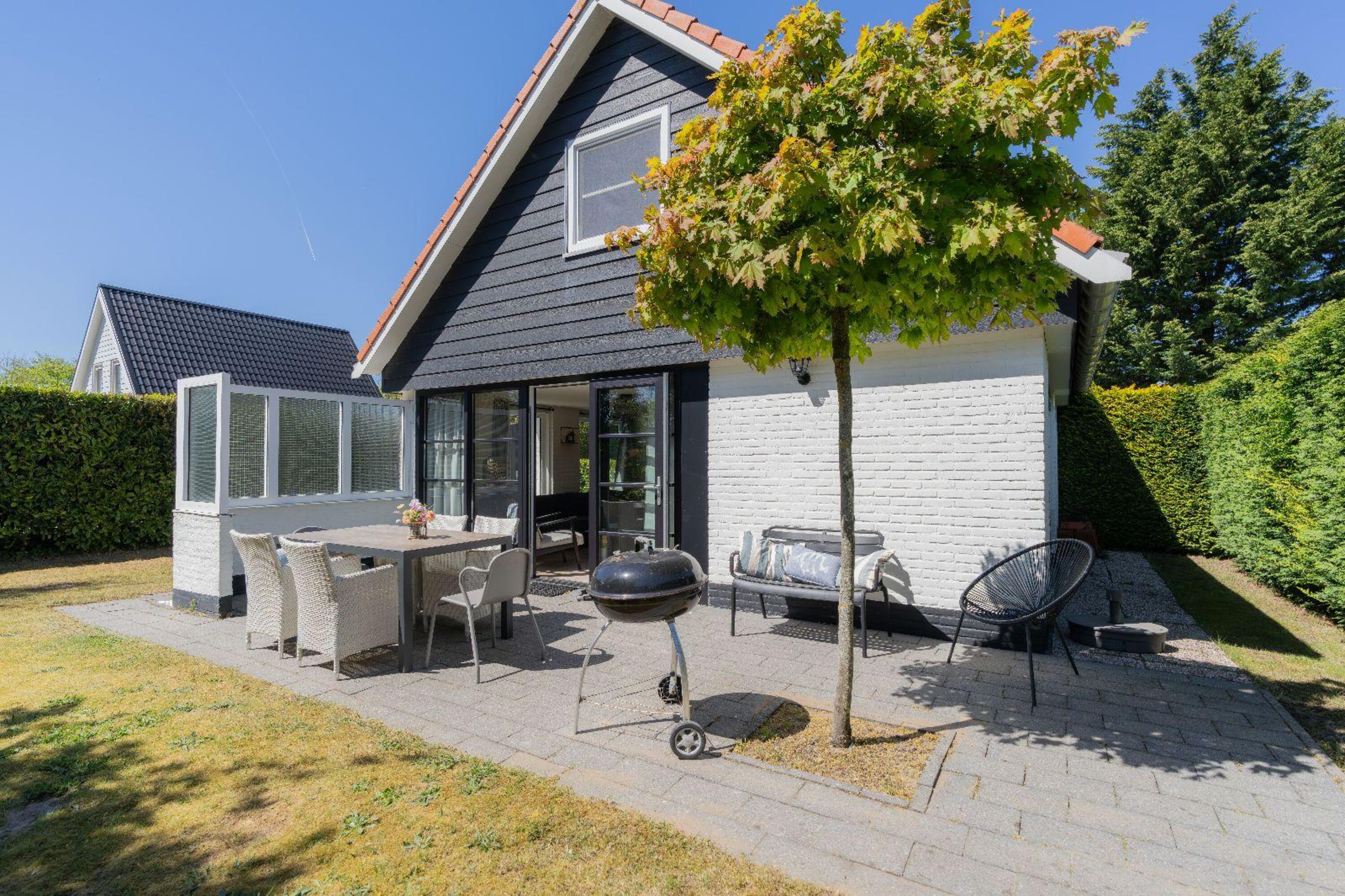 Die sonnige Terrasse mit Gartenmöbel und Grill