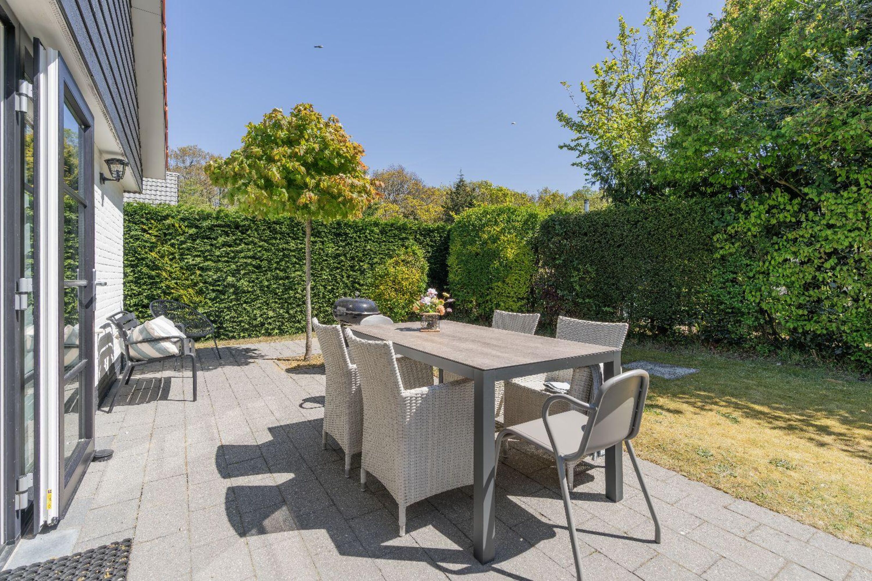 Die sonnige Terrasse mit Gartenmöbel