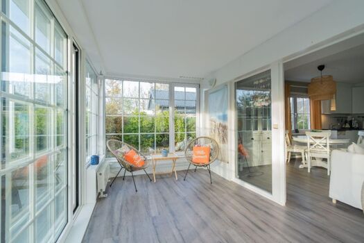 Der Wintergarten mit Kamin und Sesseln