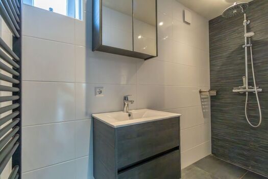 Modernes Badezimmer mit Regendusche und Waschbecken