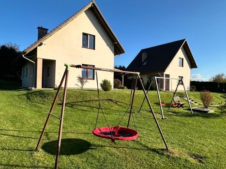 vom Spielplatz blickend auf die beiden Ferienhäuser