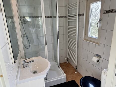 Das Bad ist mit einem Fenster, Dusche und Handtuchheizung ausgestattet.